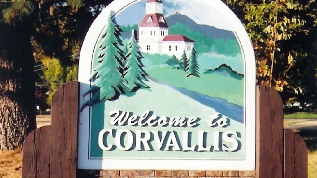 Welcome to Corvallis sign featuring a painting of a white building
